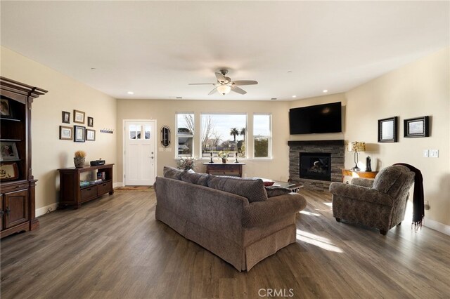 living room with ceiling fan, a fireplace, and dark hardwood / wood-style flooring