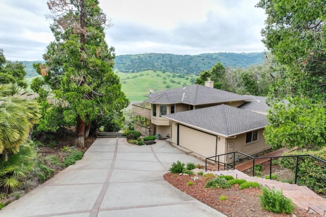 view of front property with a balcony, a garage, and a mountain view