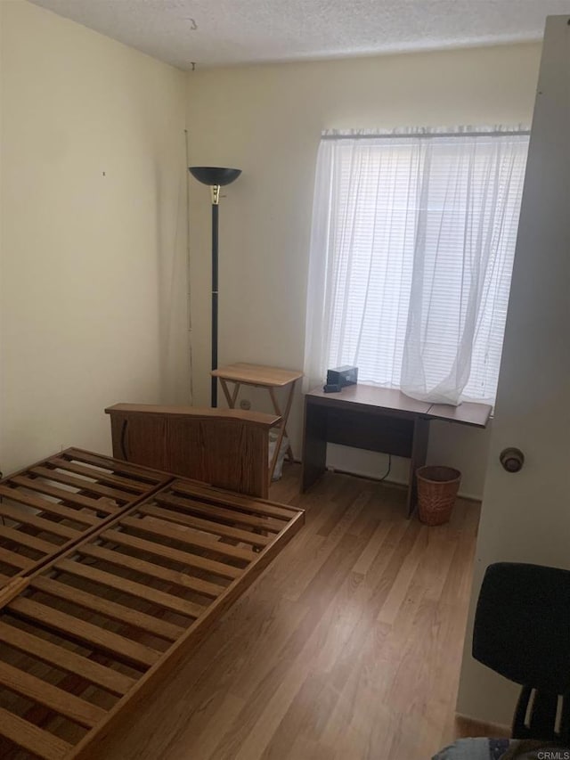 bedroom with wood-type flooring and a textured ceiling