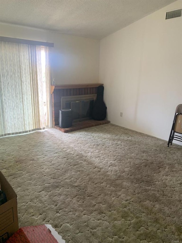 unfurnished living room with carpet floors and a textured ceiling