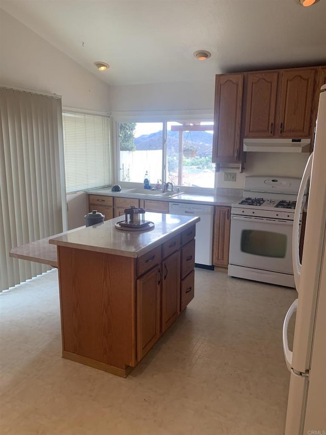 kitchen featuring white appliances, lofted ceiling, and a center island