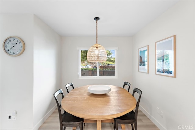 dining area with light wood finished floors and baseboards