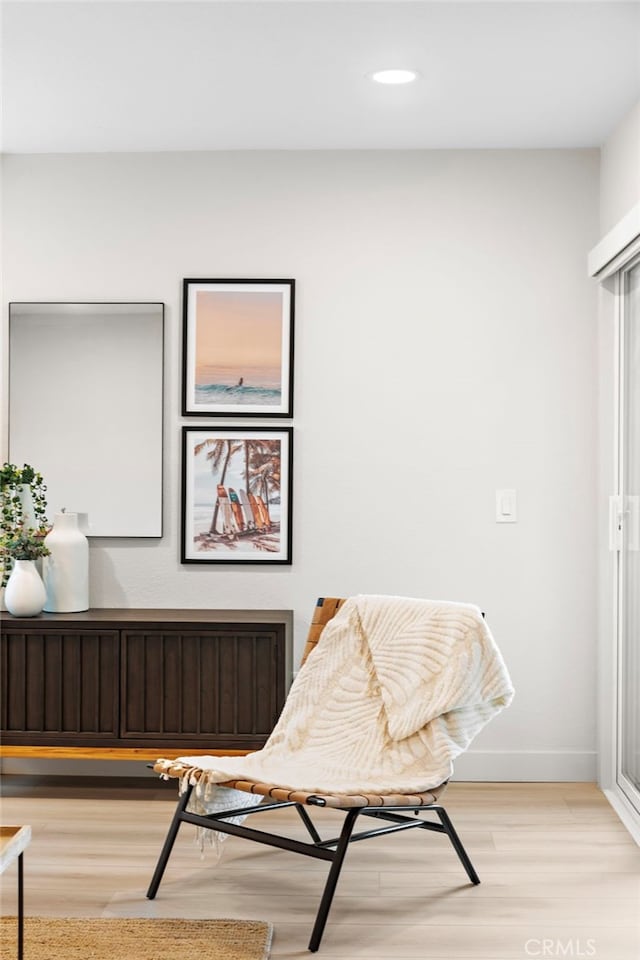 living area featuring light wood-style flooring, baseboards, radiator heating unit, and recessed lighting