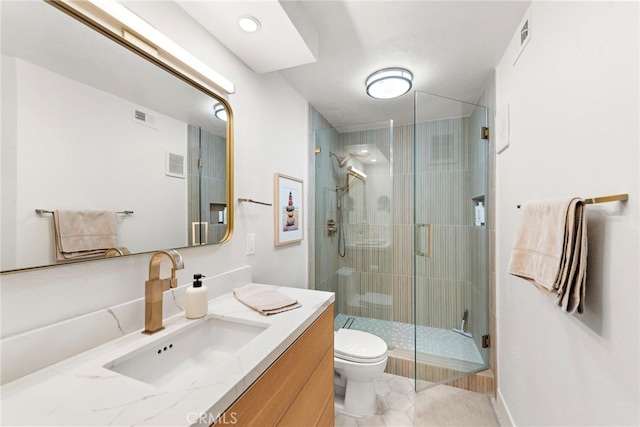 bathroom featuring tile patterned flooring, toilet, vanity, and walk in shower