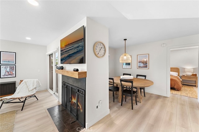 dining area with baseboards, recessed lighting, a fireplace with flush hearth, and light wood-style floors