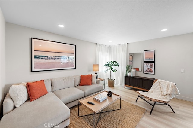 living area with light wood-type flooring and recessed lighting