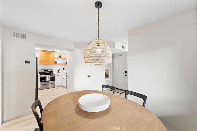 dining area with visible vents and light wood finished floors