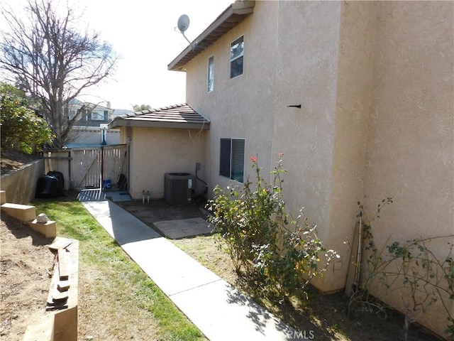 view of side of property with a patio and central AC unit