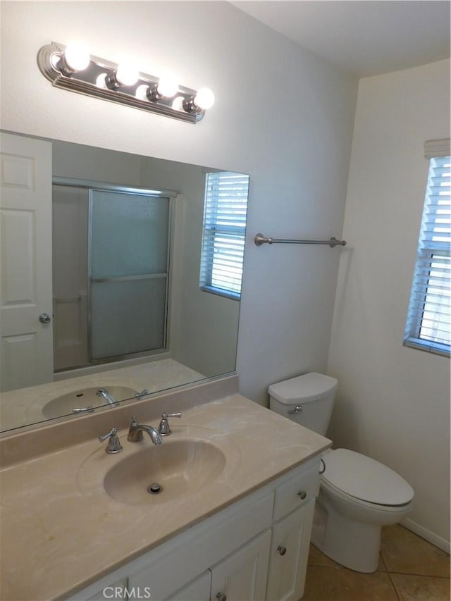 bathroom featuring vanity, toilet, tile patterned flooring, and a wealth of natural light