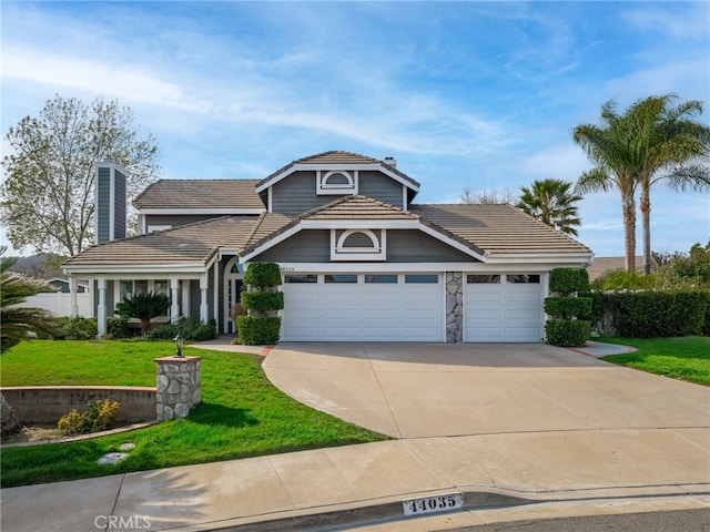 view of front of house with a tile roof, a chimney, concrete driveway, an attached garage, and a front yard