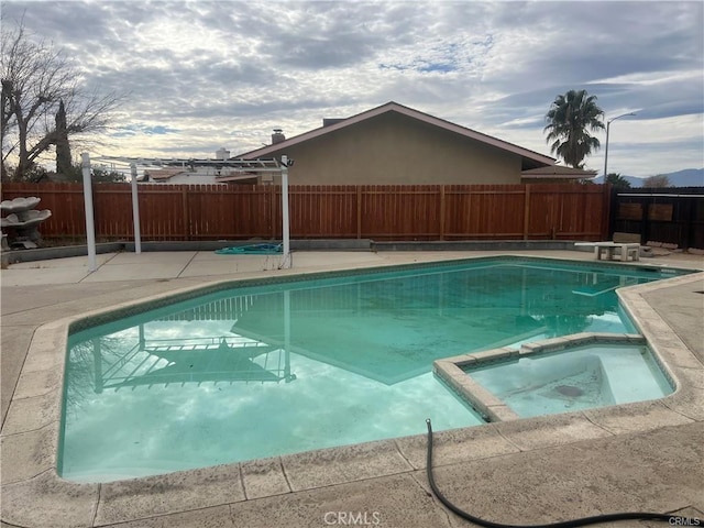 view of swimming pool with an in ground hot tub and a patio