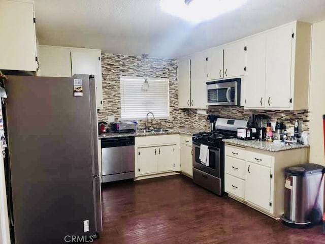 kitchen with stainless steel appliances, sink, white cabinets, and decorative backsplash