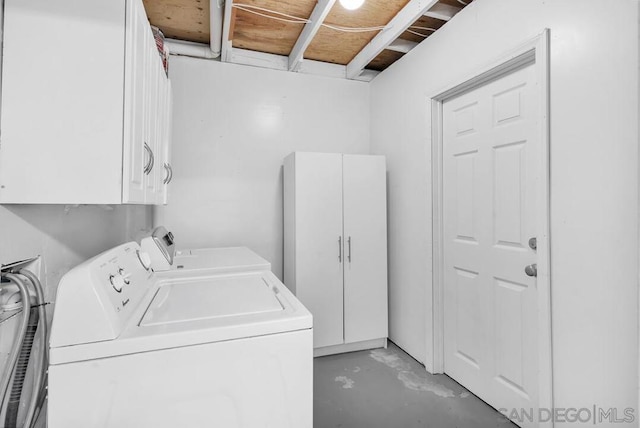 washroom featuring cabinets and washer and clothes dryer