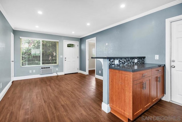 kitchen featuring ornamental molding, a wall unit AC, and dark hardwood / wood-style flooring