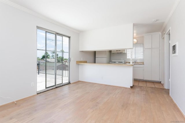 kitchen featuring light hardwood / wood-style floors, kitchen peninsula, white cabinets, and white refrigerator