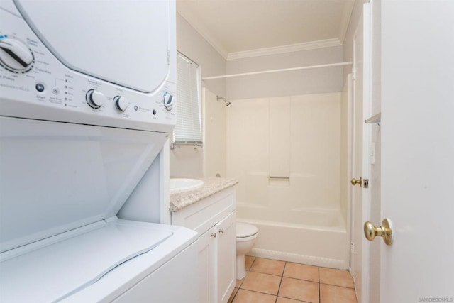 full bathroom with stacked washing maching and dryer, tile patterned flooring, vanity, toilet, and crown molding