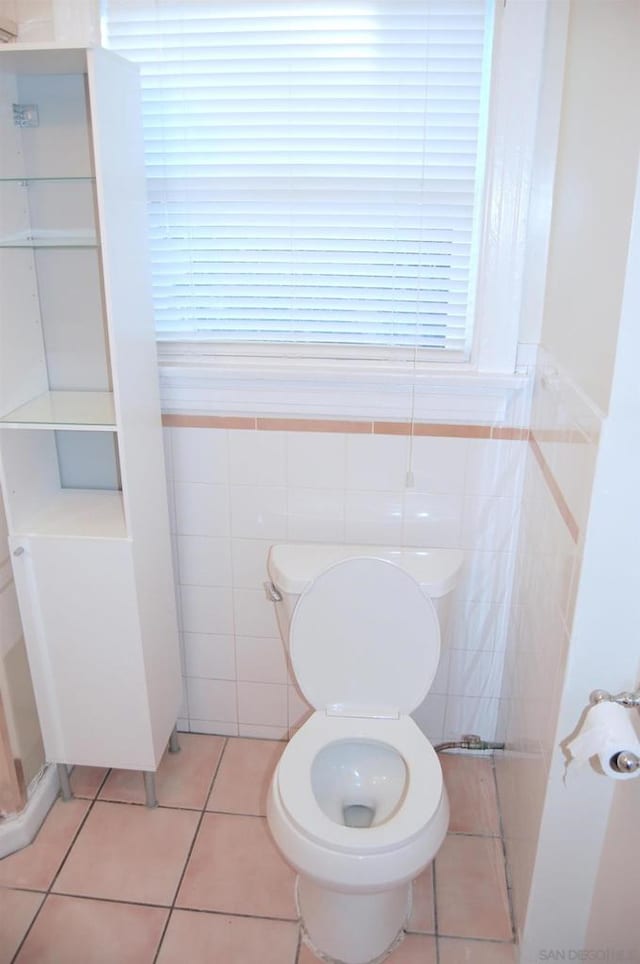 bathroom with tile walls, tile patterned floors, and toilet