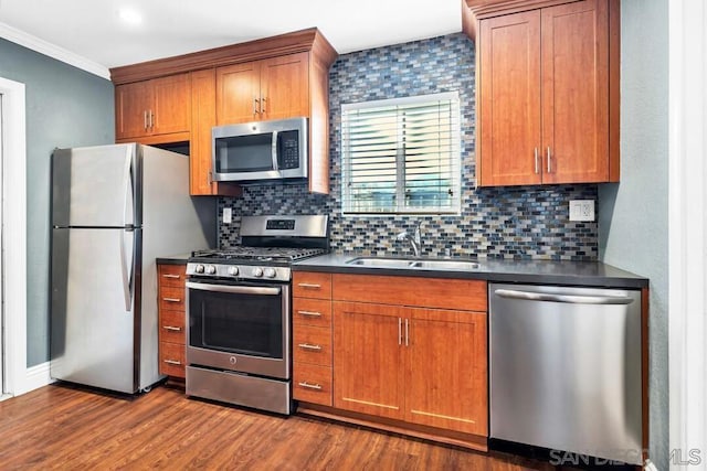 kitchen with appliances with stainless steel finishes, sink, decorative backsplash, hardwood / wood-style flooring, and ornamental molding