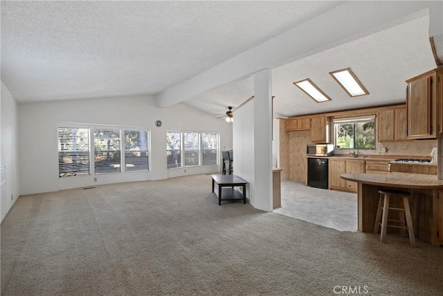 kitchen with light colored carpet, sink, a kitchen breakfast bar, and vaulted ceiling