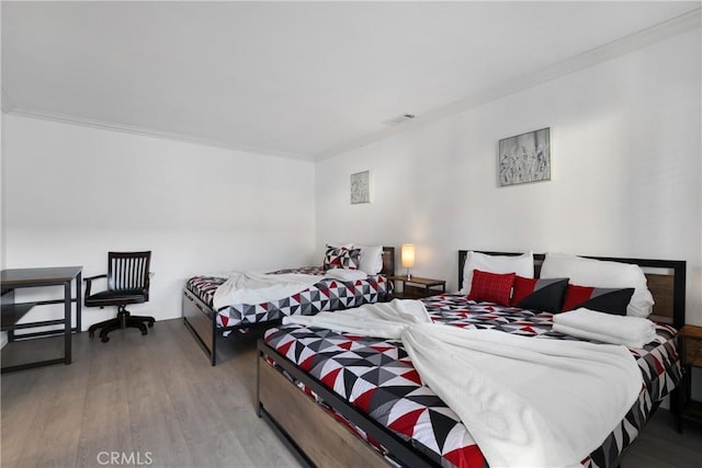 bedroom featuring crown molding and light hardwood / wood-style flooring