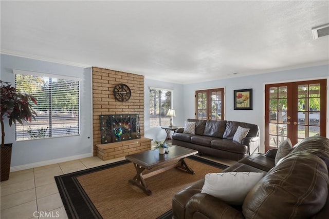 tiled living room featuring a brick fireplace, a wealth of natural light, and french doors