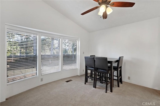 carpeted dining space featuring lofted ceiling and ceiling fan