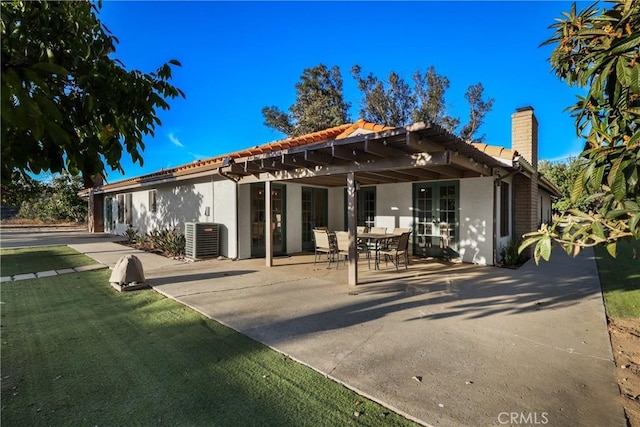 rear view of house featuring cooling unit, a pergola, and a patio