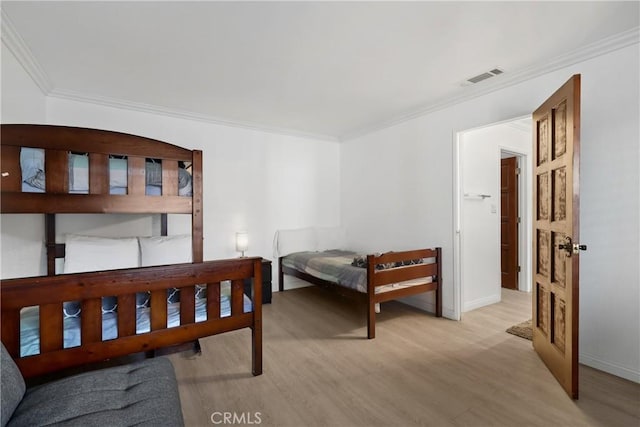 bedroom featuring ornamental molding and light hardwood / wood-style floors