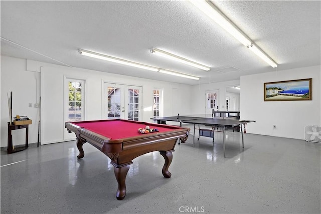 game room with billiards, a textured ceiling, and french doors