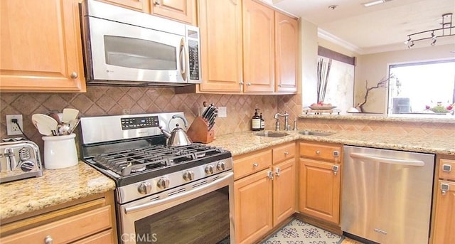 kitchen featuring light stone countertops, appliances with stainless steel finishes, sink, and decorative backsplash