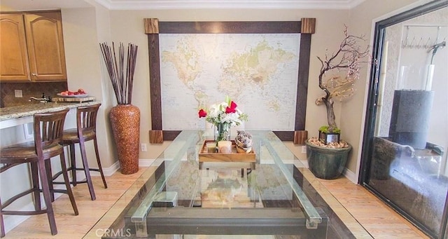 dining space featuring ornamental molding and light hardwood / wood-style floors