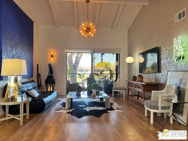 living area featuring hardwood / wood-style floors, high vaulted ceiling, beamed ceiling, wooden ceiling, and an inviting chandelier