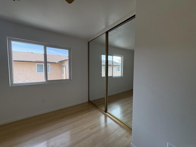 unfurnished bedroom featuring light wood-type flooring and a closet