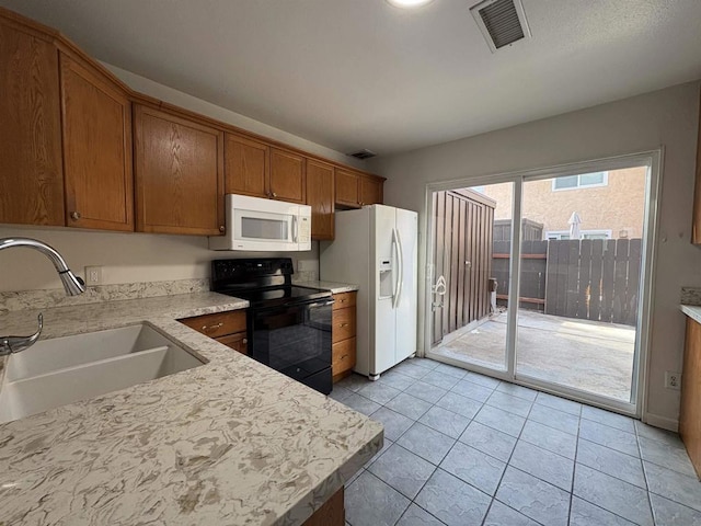 kitchen with sink, white appliances, and light tile patterned floors