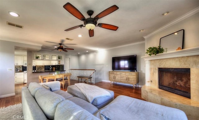 living area featuring ornamental molding, wood finished floors, and visible vents