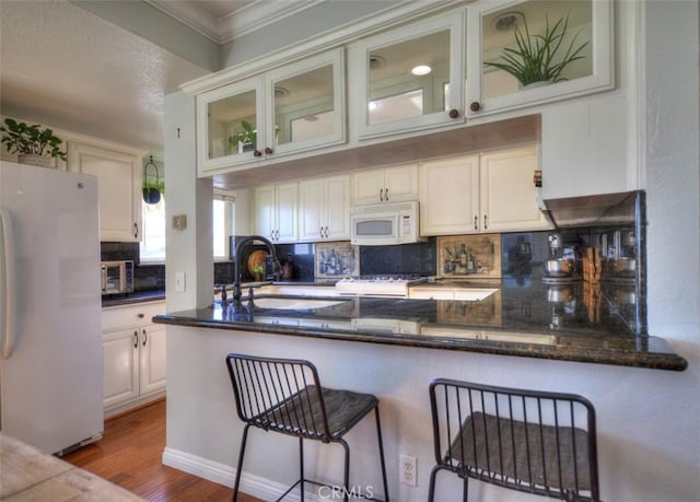 779 W 24th Unit 4, San Pedro, CA 90731 - kitchen featuring white appliances, backsplash, wood finished floors, ornamental molding, and glass insert cabinets