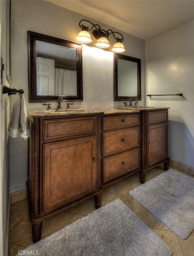 full bathroom featuring tile patterned floors, a sink, baseboards, and double vanity