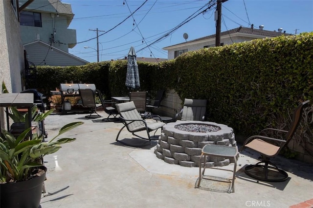 view of patio with an outdoor fire pit and fence