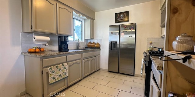 kitchen with tasteful backsplash, sink, light tile patterned flooring, and appliances with stainless steel finishes