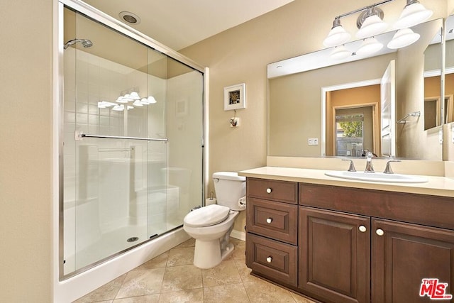 bathroom with toilet, vanity, tile patterned floors, and walk in shower