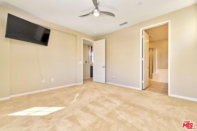 unfurnished bedroom featuring light carpet, connected bathroom, and ceiling fan