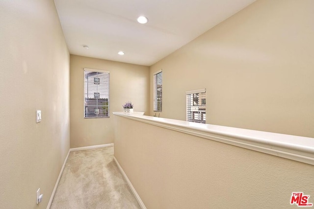 hall featuring light carpet and a wealth of natural light