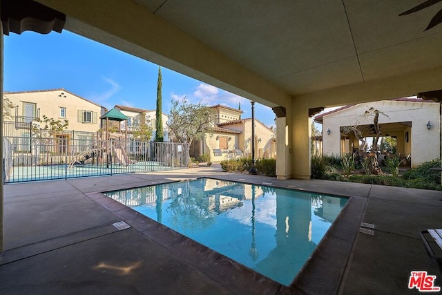 view of pool with a playground and a patio area