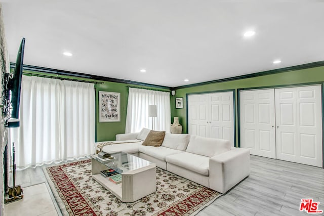 living room featuring ornamental molding and light wood-type flooring