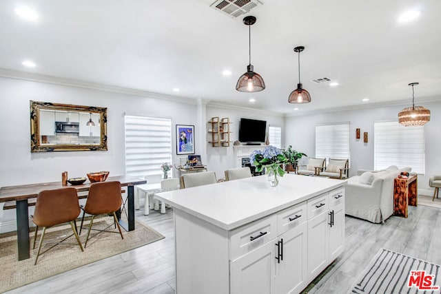 kitchen featuring pendant lighting, white cabinetry, light wood-type flooring, and a kitchen island