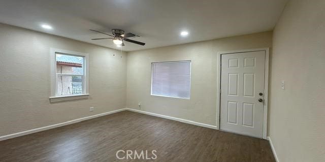 empty room featuring ceiling fan and dark hardwood / wood-style flooring