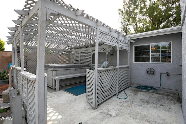 view of patio with a hot tub and a pergola