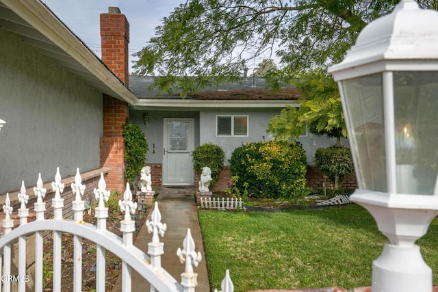 view of exterior entry with a yard