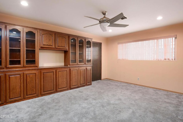 unfurnished living room with light colored carpet and ceiling fan