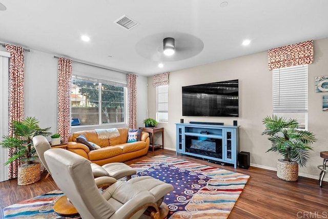 living room with ceiling fan and dark hardwood / wood-style flooring